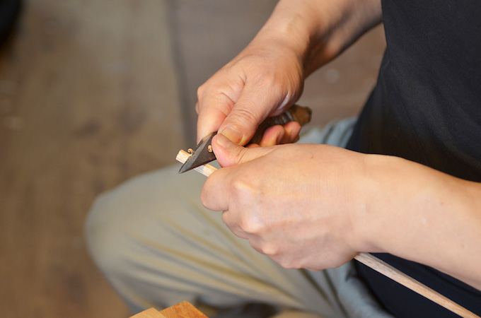 Eiji在他的工作室里修剪筷子。他特别注意筷子夹在尖端的位置。2.jpg